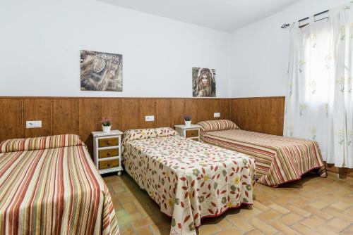 a room with two beds and two tables at Chalet Aragon Muñoz in Conil de la Frontera