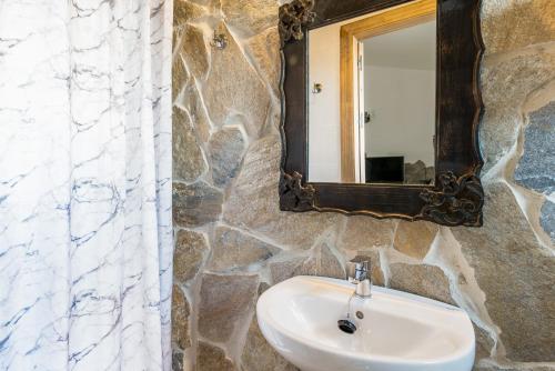 a stone bathroom with a sink and a mirror at Chalet Aragon Muñoz in Conil de la Frontera