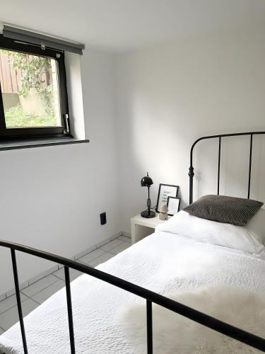 a white bedroom with a bed and a window at Ruhiges Apartment Münster Baumberge in Nottuln
