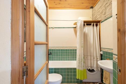 a bathroom with a tub and a toilet and a sink at Cal Panxeta in Balsareny