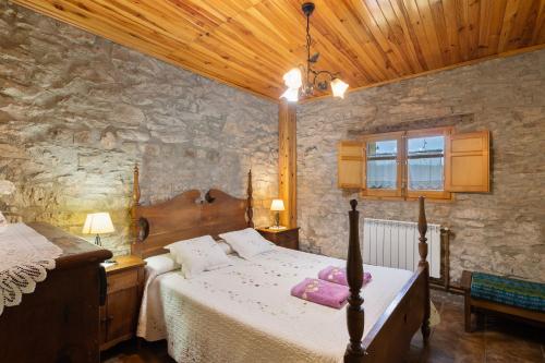 a bedroom with a bed and a stone wall at Cal Panxeta in Balsareny
