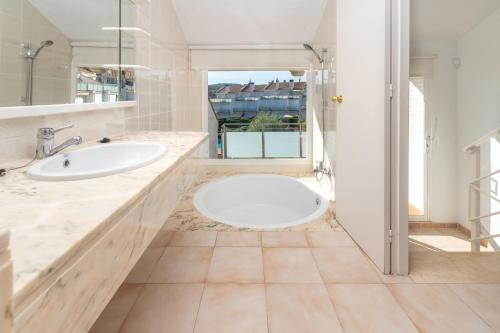a bathroom with two sinks and a large mirror at Fantàstic s'agaró in S'agaro