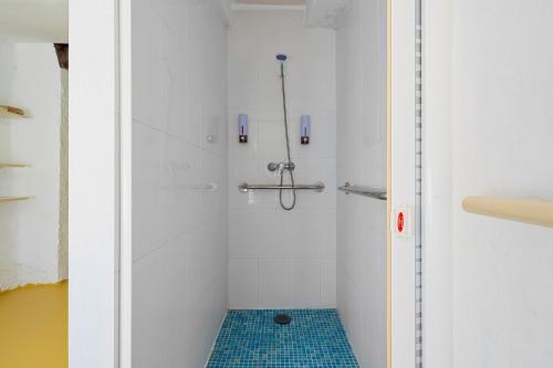 a bathroom with a shower with a blue tile floor at Ca Les Nines 2 in Pinell de Bray
