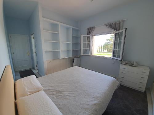 a bedroom with a large white bed and a window at Finca Campo Viejo in Isla Cristina