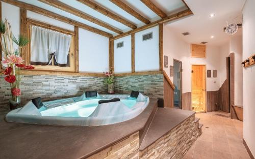 a large tub in a room with a brick wall at Agritur Sotto il Melo in Caldes