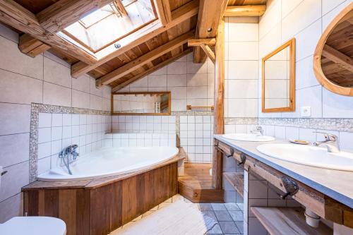 a bathroom with two sinks and a tub at Chalet La Grange des Flocons in Valloire