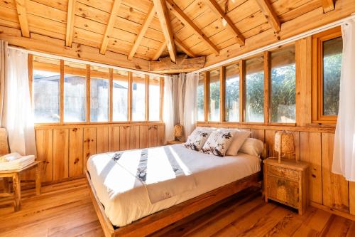 a bedroom with a bed in a room with windows at Villa Bayani in Lacanau
