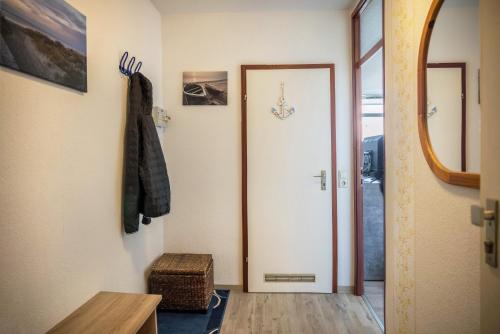 a hallway with a white door and a mirror at Ferienpark N3 -3 in Heiligenhafen