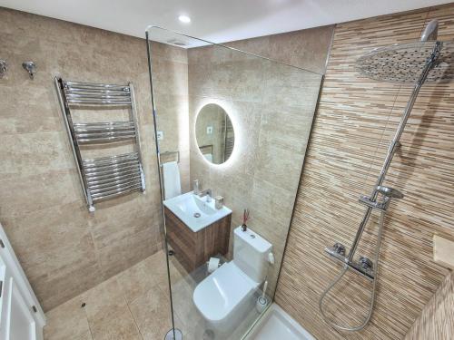 a bathroom with a toilet and a sink and a shower at Townhouse overlooking golf course in Las Armeras