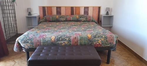 a bedroom with a bed with a bench in it at B e B Beglia Alguer in Alghero