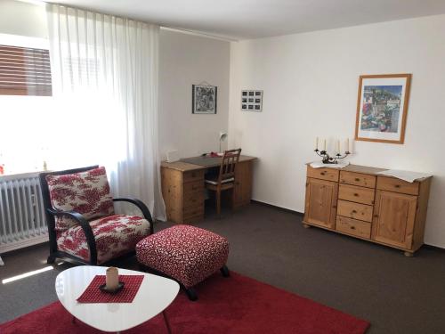 a living room with a chair a table and a desk at Ferienwohnung Innenstadt in Marktbreit