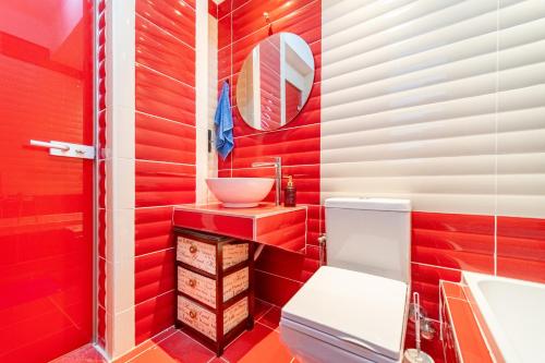 a red bathroom with a sink and a toilet at The Mountain Villa in Aleimmatádes