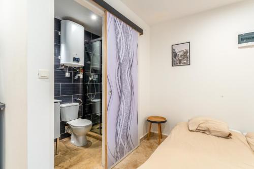 a bedroom with a bed and a toilet and a shower at Canto Cigalo Rdc 1 in Robion en Luberon