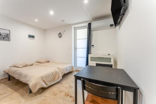 a bedroom with a bed and a table and a window at Canto Cigalo Rdc 1 in Robion en Luberon