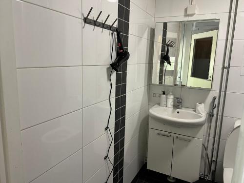 a white bathroom with a sink and a mirror at Kangaskartano Yksiö in Keitelepohja