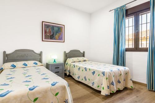 a bedroom with two beds and a window at Chalet Rubio Cabeza in Conil de la Frontera