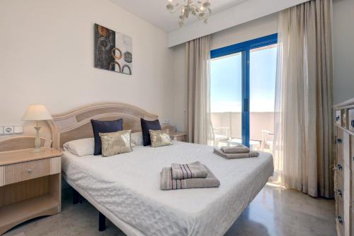 a bedroom with a large bed and a large window at La Terraza del Mar in Manilva