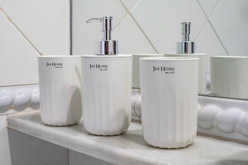 three white bottles sitting on a counter in a bathroom at Kiko Las Americas in Isla Cristina