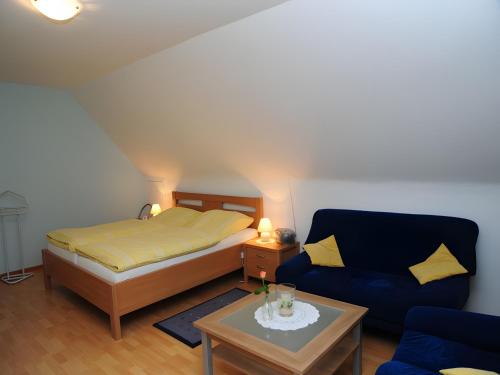 a bedroom with a bed and a couch and a table at Kuryhof in Simonswald