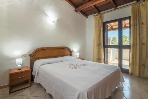 a bedroom with a bed and a large window at Quadrilocale 800mt dal mare in San Teodoro