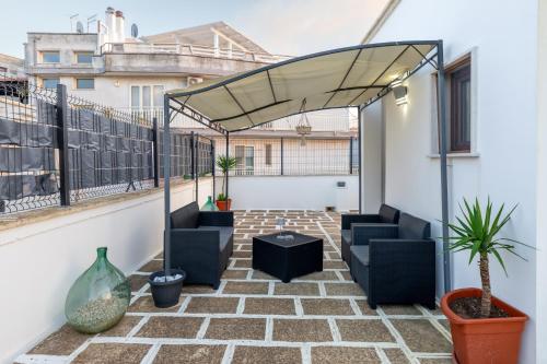 a patio with chairs and a canopy on a balcony at L'aurora in San Vito dei Normanni