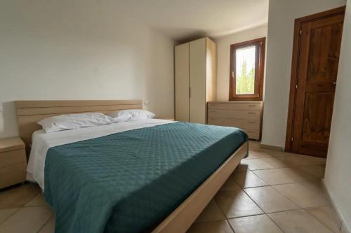 a bedroom with a large bed and a window at Villa Vigna in Badesi