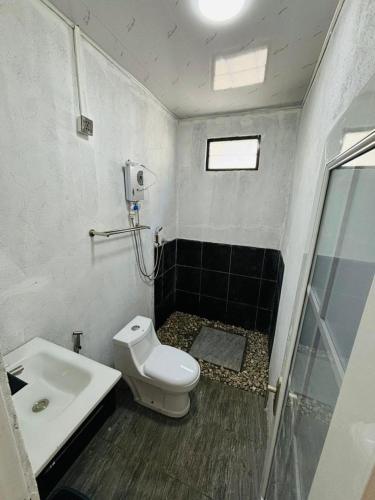 a bathroom with a toilet and a sink at JE Garden Guesthouse in Oecusse RAEOA in Deli