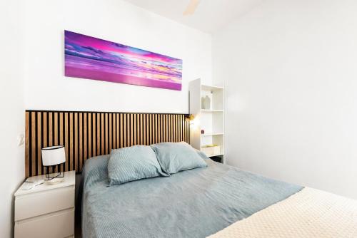 a bedroom with a bed and a painting on the wall at Apartamento Lucía in Torre del Mar