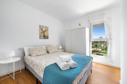 a white bedroom with a bed and a window at Lopimar Bonito in Canet de Berenguer