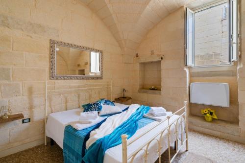 a bedroom with a bed with a mirror and a window at Corte Cochlea La Curte Suite per 4 in Cannole