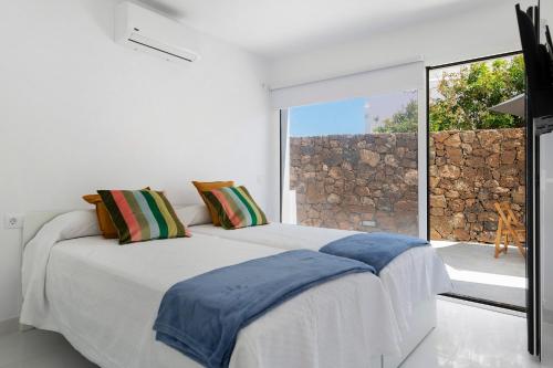 a bedroom with a bed and a large window at Noray 2 in La Santa