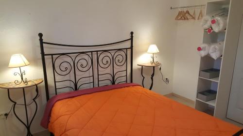 a bedroom with an orange bed with two lamps at Gîte Du Vignal in Mazeyrat-d'Allier