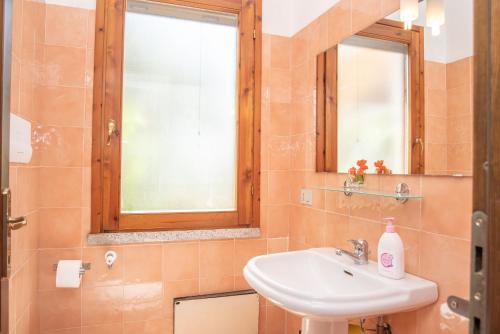 a bathroom with a sink and a mirror at Sardegna Budoni giardino e Jacuzzi in Budoni