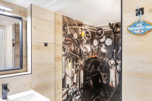 a bathroom with a wall covered in clocks at Waldhaus zur Kleinbahn in Glashütte