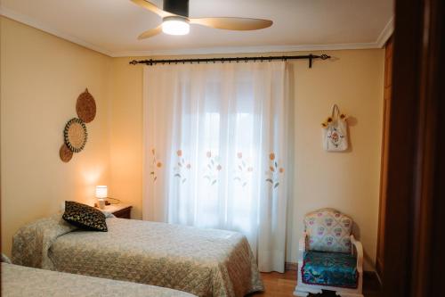 a bedroom with two beds and a chair at Ca Margarita in Benegida