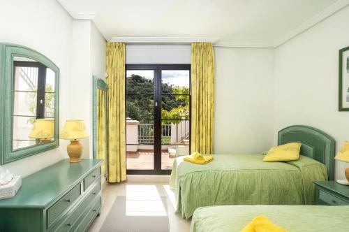 a bedroom with two beds and a window at Beautiful penthouse with solarium in Benahavís