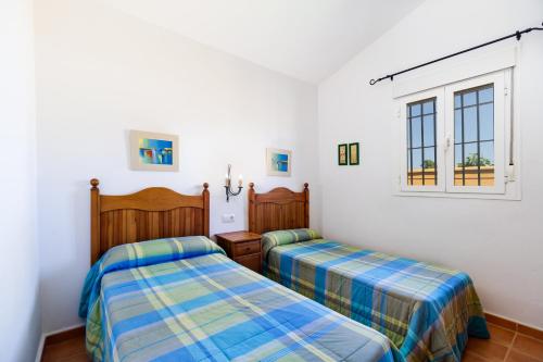 a bedroom with two beds and a window at Luisa 2 in Conil de la Frontera