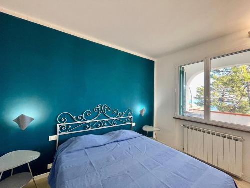 a blue bedroom with a bed and a blue wall at Villetta My Sea in Spotorno