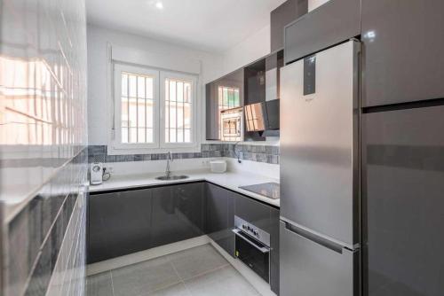 a white kitchen with a refrigerator and a sink at Apartamento Torero ii in Marchena