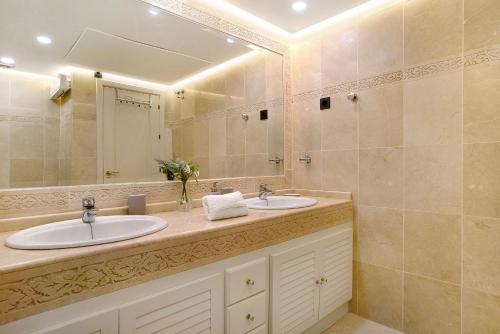 a bathroom with two sinks and a large mirror at Luxury in Puerto Marina in Benalmádena