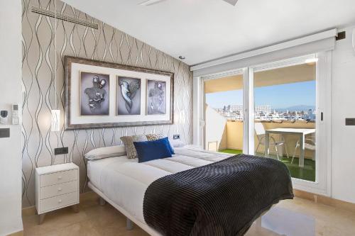 a bedroom with a large bed and a large window at Luxury in Puerto Marina in Benalmádena