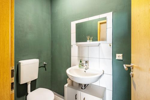 a green bathroom with a toilet and a sink at Haus Wipperblick in Osmarsleben
