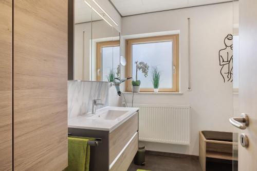 a bathroom with a sink and a mirror at Ferienwohnung Janko in Meßstetten