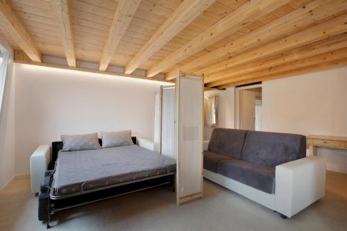 a small bedroom with a bed and a couch at Maison Millet Ozein in Aymavilles