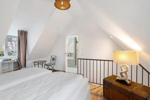 a bedroom with a bed and a lamp and a table at Altes Kutschhaus in Gernsbach