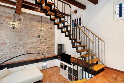 a spiral staircase in a living room with a couch at Altes Kutschhaus in Gernsbach