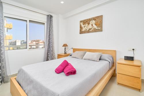 a bedroom with a bed with pink pillows on it at Playa Algarrobo Costa in Algarrobo-Costa