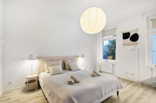 a white bedroom with a large bed with two shoes on it at Ferienwohnung Agnes in Dessau