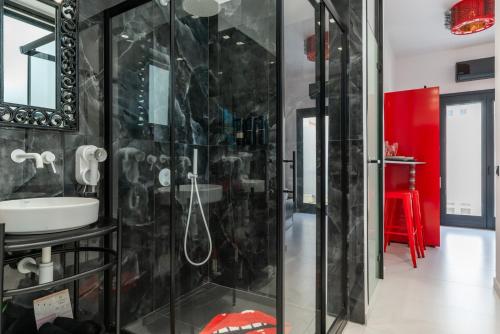 a bathroom with a glass shower and a sink at Artrock Experience Loft Gallery in Ermoupoli
