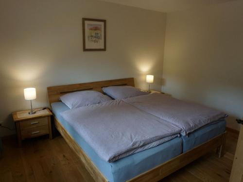 a bed in a bedroom with two lamps on tables at Ferienhaus am Leiselbach in Leisel